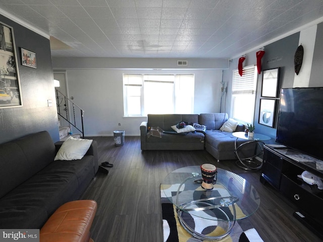 living area with visible vents, stairway, baseboards, and wood finished floors