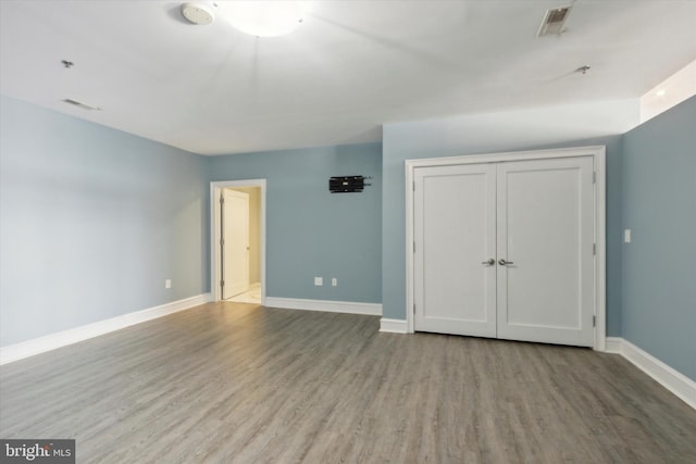 unfurnished bedroom featuring a closet and hardwood / wood-style flooring