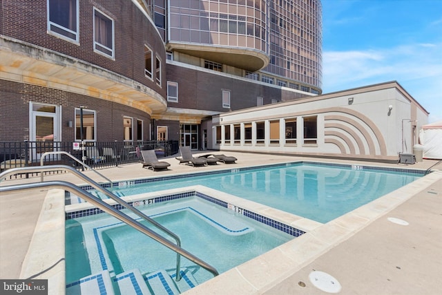 view of pool featuring a community hot tub and a patio area