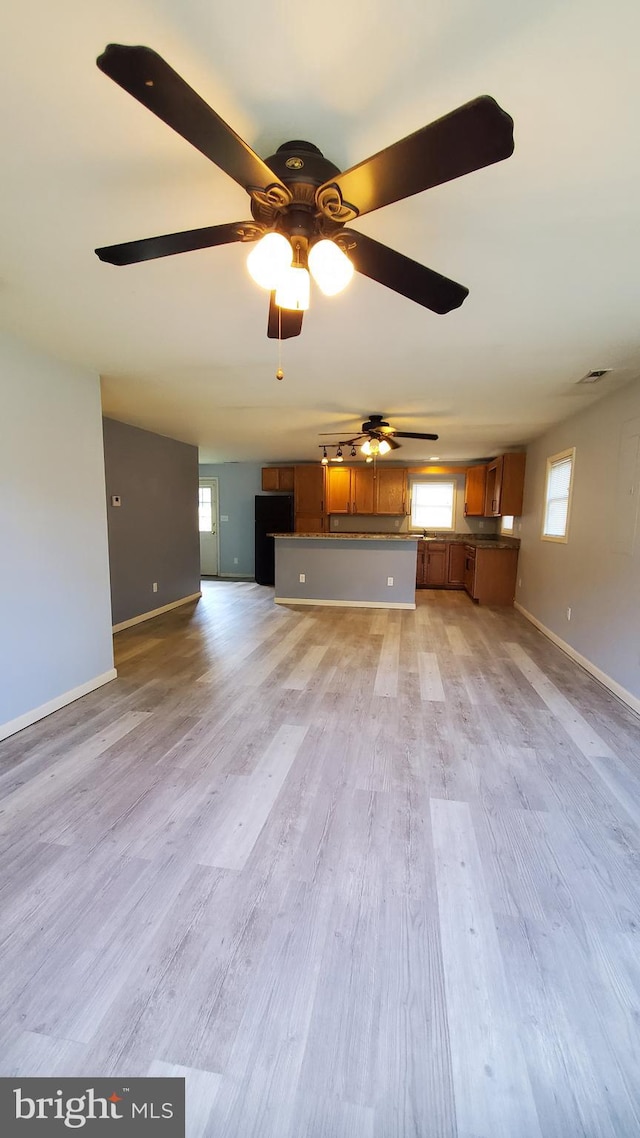 unfurnished living room featuring light hardwood / wood-style flooring and ceiling fan