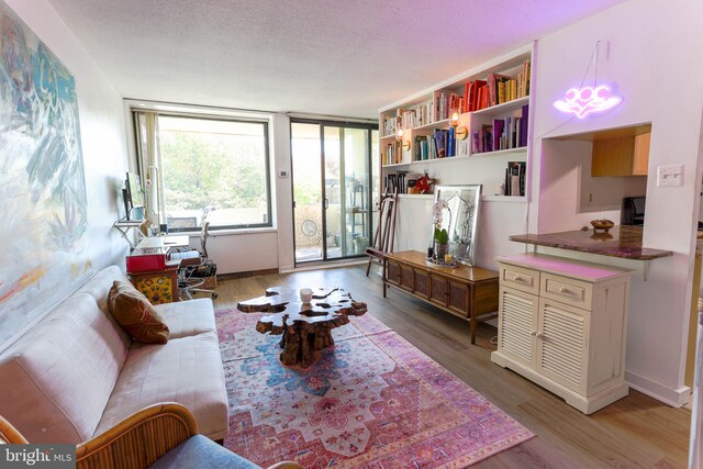 living area with light wood-type flooring and a textured ceiling