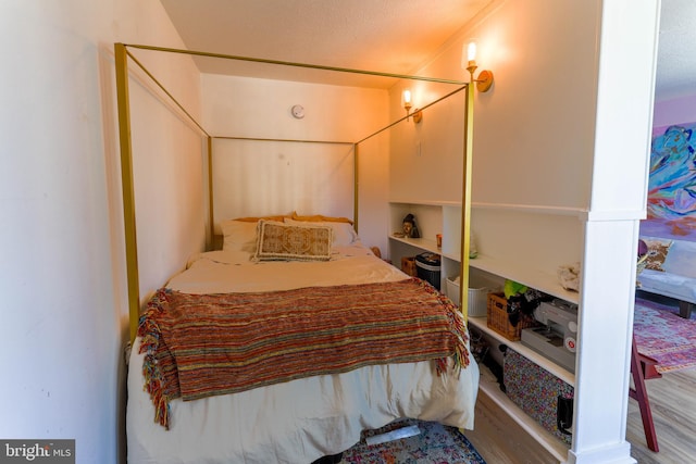 bedroom featuring hardwood / wood-style flooring and a textured ceiling