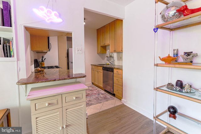 kitchen featuring hanging light fixtures, stainless steel appliances, and light hardwood / wood-style floors