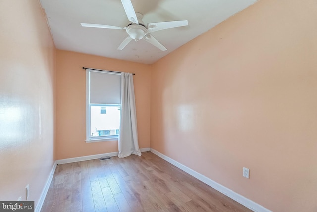 unfurnished room with ceiling fan, light wood-style floors, visible vents, and baseboards