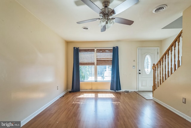 foyer featuring visible vents, stairway, baseboards, and wood finished floors