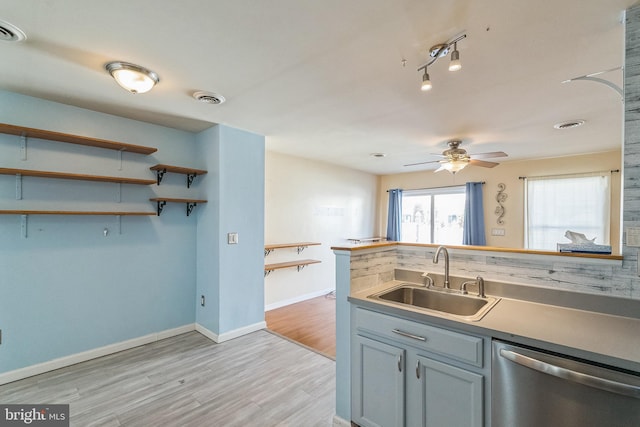 kitchen with light wood finished floors, visible vents, baseboards, dishwasher, and a sink