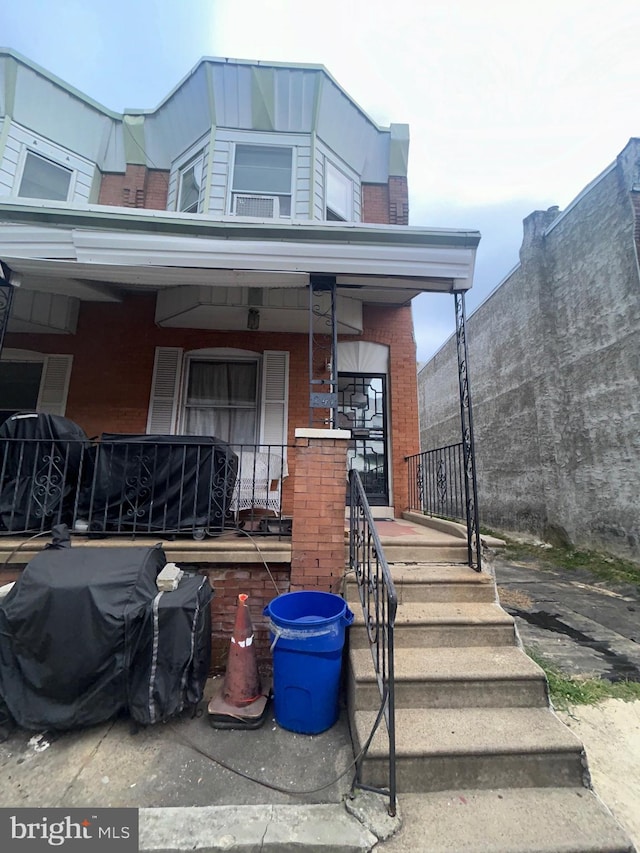 view of front of property featuring a porch and brick siding