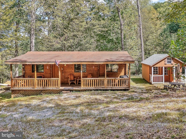 log cabin with a deck and a shed