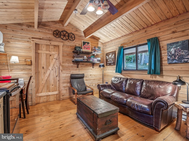 living room featuring ceiling fan, vaulted ceiling with beams, and light wood-type flooring