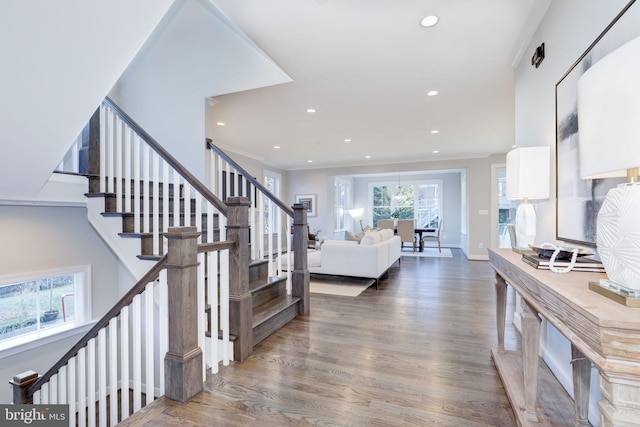 staircase with ornamental molding and wood-type flooring