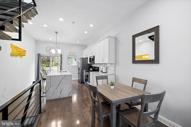 dining area with sink, a notable chandelier, and dark hardwood / wood-style floors