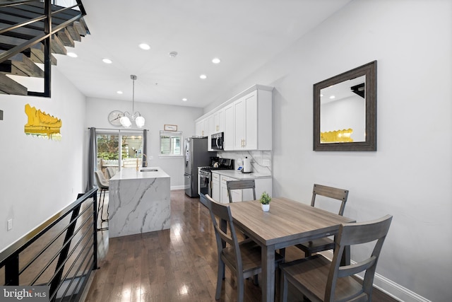 dining area featuring a notable chandelier, recessed lighting, dark wood-type flooring, and baseboards