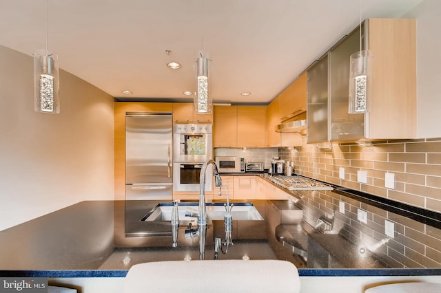 kitchen with light brown cabinets, a sink, decorative backsplash, stainless steel appliances, and under cabinet range hood