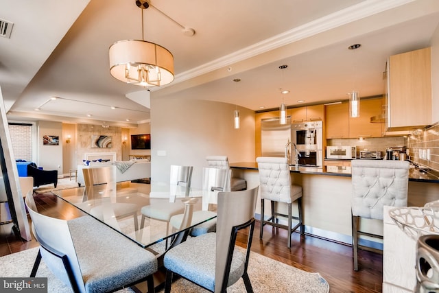 dining area with visible vents, dark wood finished floors, recessed lighting, crown molding, and a chandelier