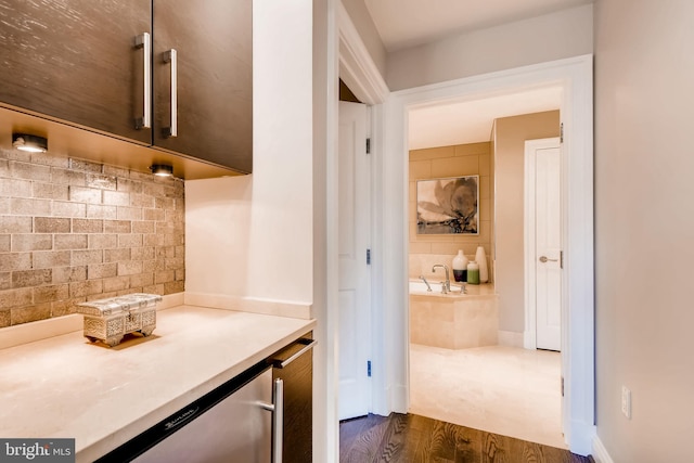 interior space featuring backsplash, dark wood-type flooring, and a dry bar