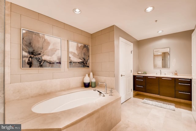 full bath featuring vanity, tile walls, a bath, and recessed lighting