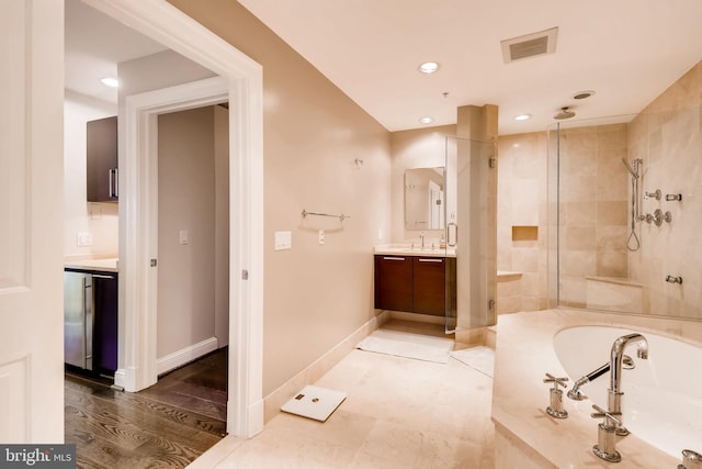 full bathroom with visible vents, a garden tub, a shower stall, baseboards, and vanity