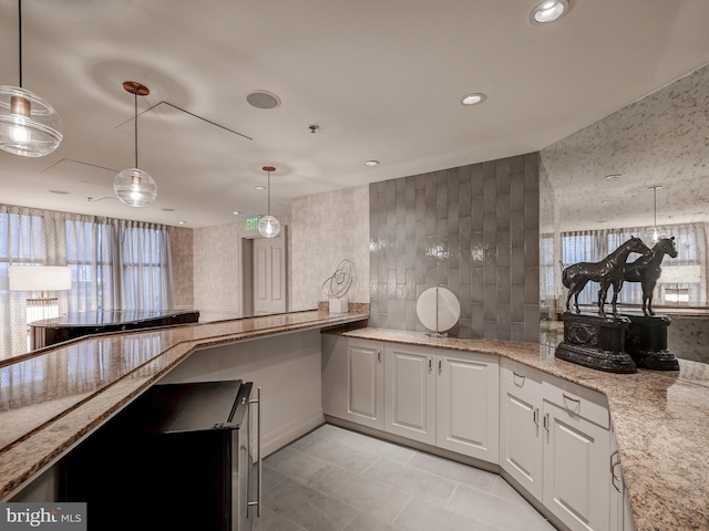 kitchen featuring decorative light fixtures, recessed lighting, white cabinets, light tile patterned floors, and light stone countertops