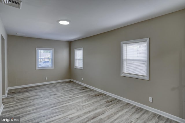 empty room featuring a wealth of natural light and light hardwood / wood-style floors