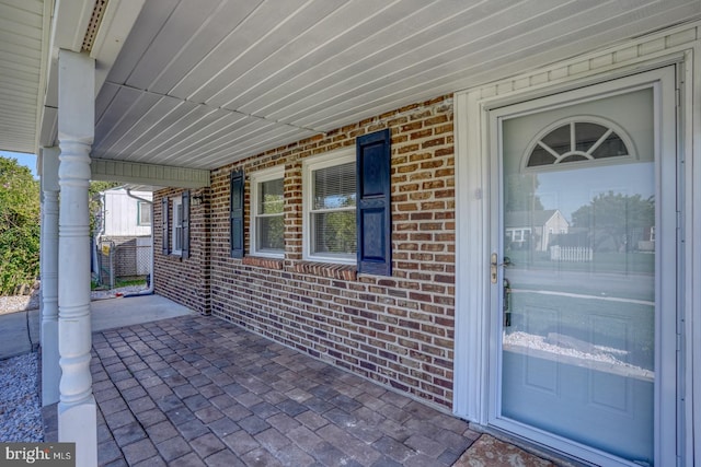 view of exterior entry featuring covered porch