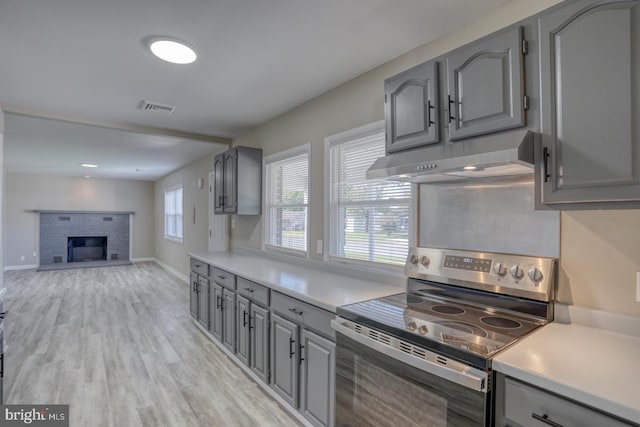 kitchen featuring gray cabinetry, stainless steel electric stove, and light hardwood / wood-style floors