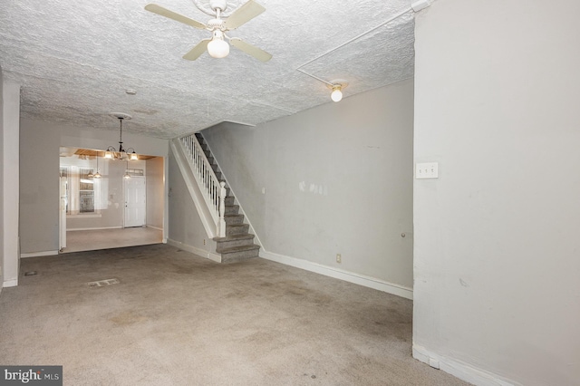 unfurnished living room featuring carpet, a textured ceiling, and ceiling fan