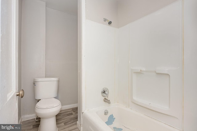 bathroom featuring toilet, hardwood / wood-style flooring, and shower / bathing tub combination