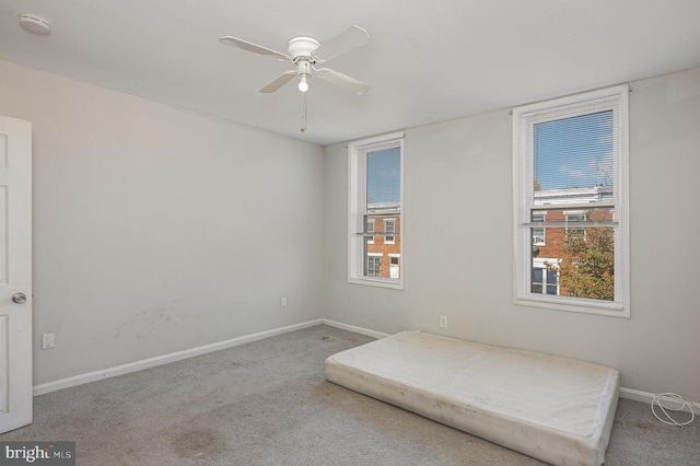 carpeted bedroom with multiple windows and ceiling fan