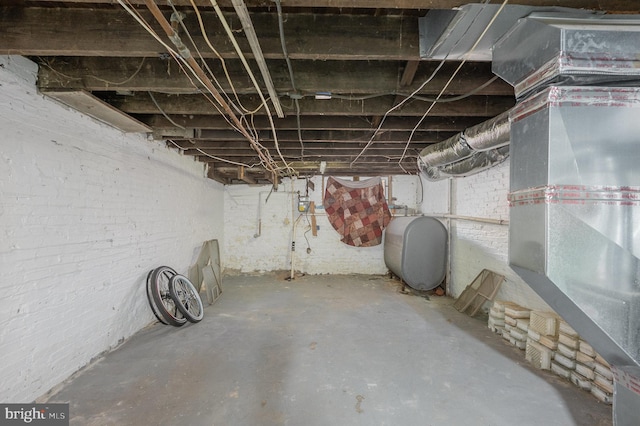 basement with brick wall and heating unit