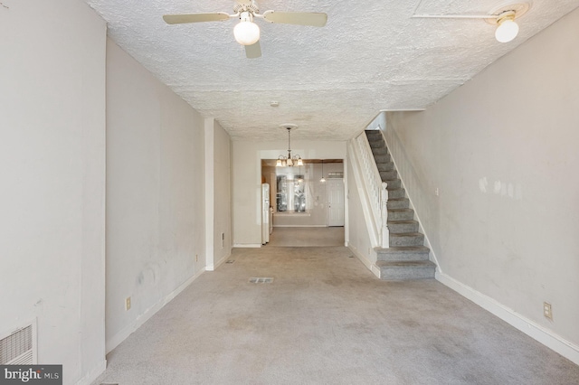 interior space with a notable chandelier, light carpet, and a textured ceiling