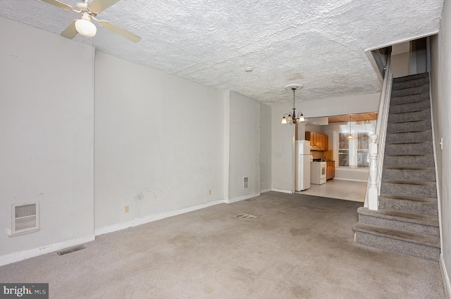 unfurnished living room with ceiling fan, a textured ceiling, and light colored carpet