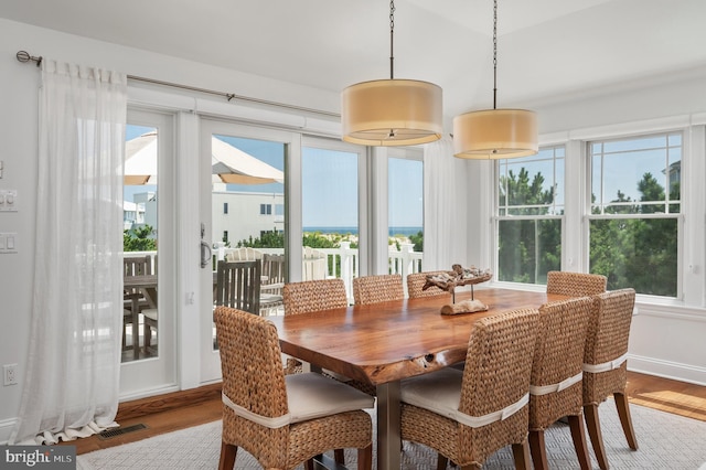 dining room with baseboards, visible vents, and wood finished floors