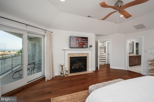 bedroom with access to exterior, lofted ceiling, visible vents, a fireplace with flush hearth, and wood finished floors