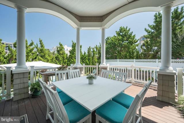 deck featuring outdoor dining space and fence