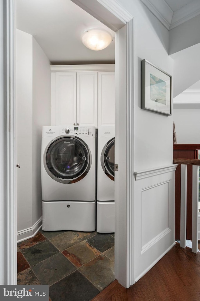 laundry area with ornamental molding, cabinet space, washing machine and dryer, and stone tile flooring