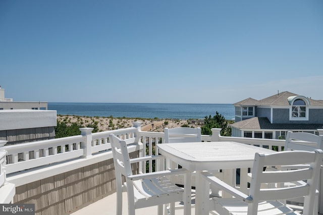 balcony featuring a view of the beach and a water view