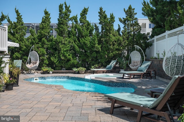 pool featuring a fenced backyard, a patio, and an in ground hot tub