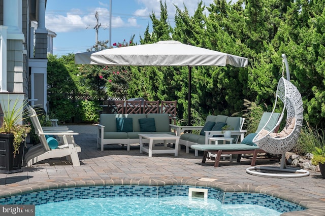 view of swimming pool featuring a patio area, fence, and an outdoor hangout area