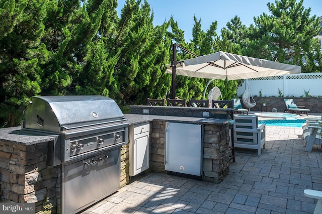 view of patio featuring fence and an outdoor kitchen