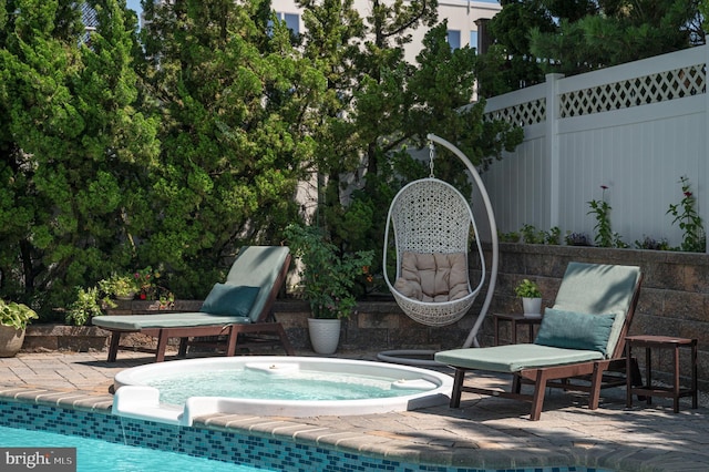 view of pool featuring an outdoor hot tub, a patio area, and fence