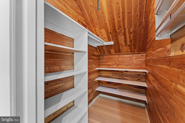 spacious closet with light wood-type flooring and vaulted ceiling