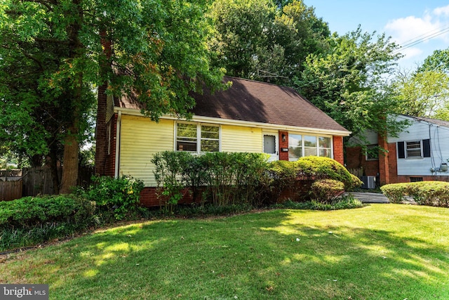 view of front of property featuring cooling unit and a front lawn