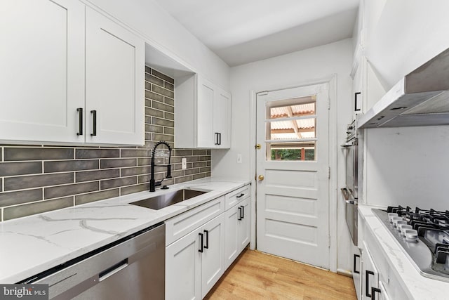 kitchen with light stone counters, sink, stainless steel dishwasher, white cabinetry, and gas cooktop