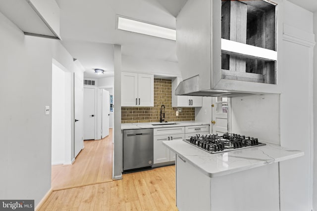 kitchen with light hardwood / wood-style floors, sink, white cabinets, stainless steel appliances, and light stone countertops