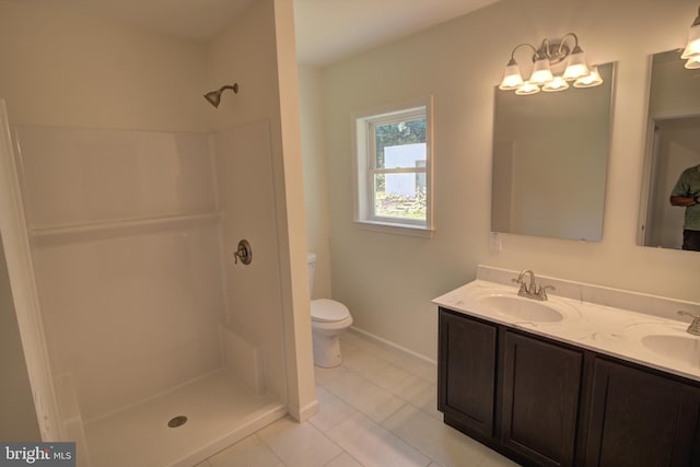 bathroom featuring a shower, tile patterned flooring, vanity, and toilet