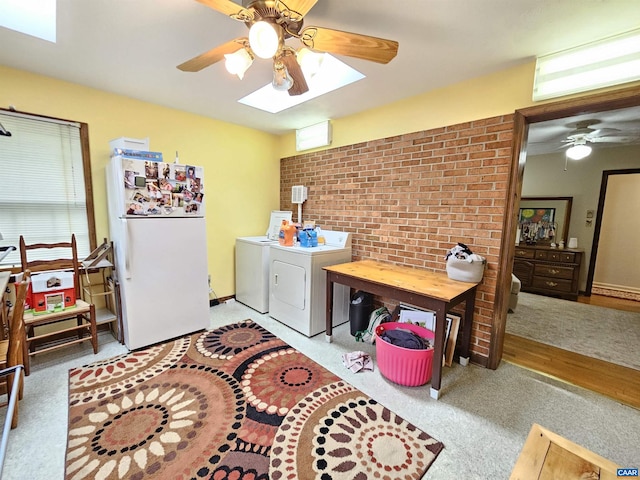 office space with a skylight, ceiling fan, light colored carpet, and separate washer and dryer