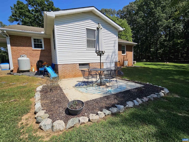 rear view of house featuring a lawn and a patio