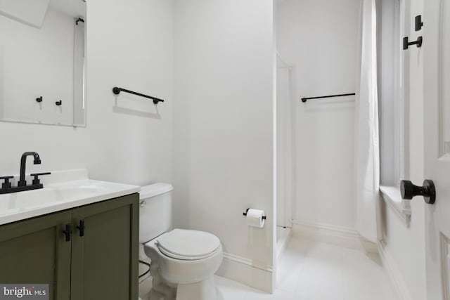 bathroom featuring walk in shower, toilet, and vanity