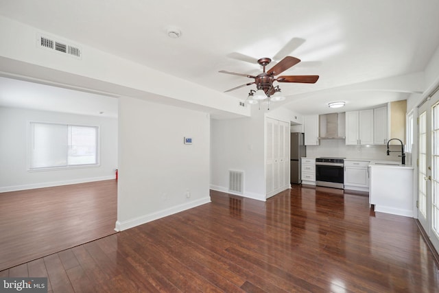 unfurnished living room with ceiling fan, sink, and dark hardwood / wood-style floors