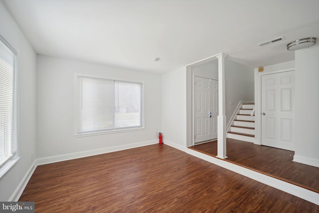 unfurnished room with dark hardwood / wood-style flooring and a healthy amount of sunlight